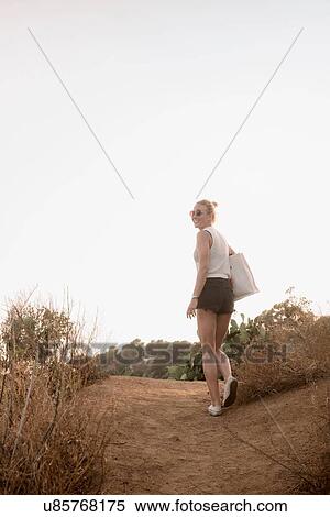 Woman walking along rural pathway, rear view, Tossa de mar, Catalonia, Spain View Large Photo Image Stock Photography - Woman walking along rural pathway, rear view, Tossa de mar, Catalonia, Spain. Fotosearch