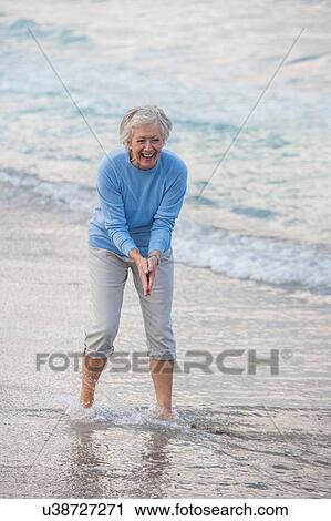 Woman washing hand with sea water View Large Photo Image Stock Image - Woman washing hand with sea water. Fotosearch