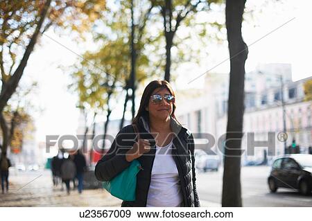 Woman wearing sunglasses walking in street, Lisbon, Portugal, Europe View Large Photo Image Stock Photo - Woman wearing sunglasses walking in street, Lisbon, Portugal, Europe. Fotosearch