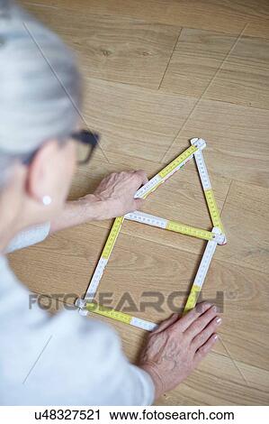 Woman with house shaped tape measure on floor View Large Photo Image Stock Image - Woman with house shaped tape measure on floor. Fotosearch