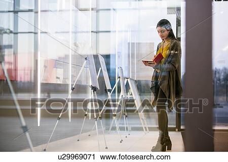 Stock Image - Woman with notepad in office. Fotosearch