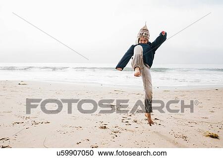 Young boy on beach, jumping, mid air View Large Photo Image Stock Image - Young boy on beach, jumping, mid air. Fotosearch
