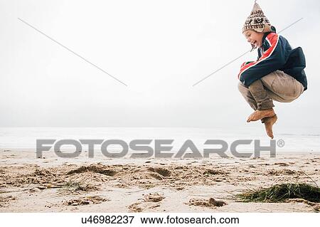Young boy on beach, jumping, mid air View Large Photo Image Stock Photo - Young boy on beach, jumping, mid air. Fotosearch