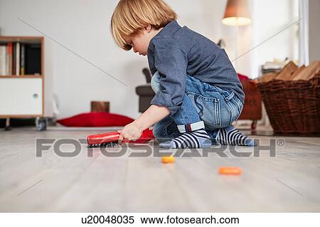 Young boy playing with toy dustpan and brush View Large Photo Image Stock Photography - Young boy playing with toy dustpan and brush. Fotosearch