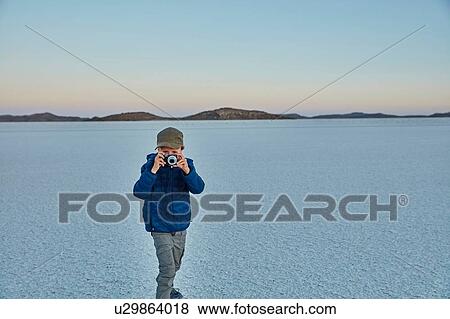 Young boy standing on salt flats, looking through camera, Salar de Uyuni, Uyuni, Oruro, Bolivia, South America View Large Photo Image Stock Photo - Young boy standing on salt flats, looking through camera, Salar de Uyuni, Uyuni, Oruro, Bolivia, South America. Fotosearch