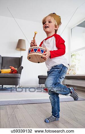 Young boy wearing cardboard crown, beating toy drum, low angle view View Large Photo Image Stock Image - Young boy wearing cardboard crown, beating toy drum, low angle view. Fotosearch