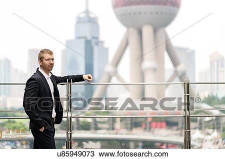 Young businessman leaning on handrail at Shanghai financial centre, Shanghai, China View Large Photo Image Stock Image - Young businessman leaning on handrail at Shanghai financial centre, Shanghai, China. Fotosearch