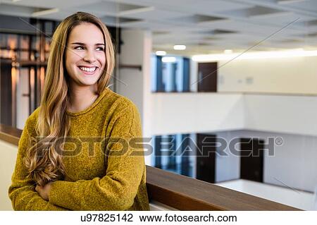 Young businesswoman looking over her shoulder in office atrium, head and shoulders View Large Photo Image Stock Image - Young businesswoman looking over her shoulder in office atrium, head and shoulders. Fotosearch
