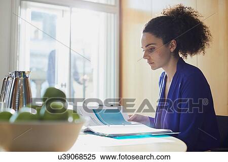 Young businesswoman reading paperwork at office desk View Large Photo Image Stock Photography - Young businesswoman reading paperwork at office desk. Fotosearch