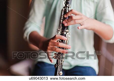 Stock Image - Young clarinettist playing her clarinet. Fotosearch