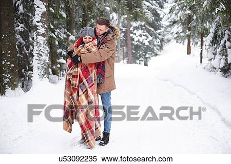 Stock Photography - Young couple hugging in snow. Fotosearch