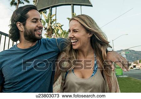 Stock Image - Young couple, outdoors, laughing. Fotosearch