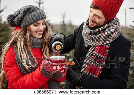Young couple pouring coffee while shopping for christmas tree from forest View Large Photo Image Stock Image - Young couple pouring coffee while shopping for christmas tree from forest. Fotosearch