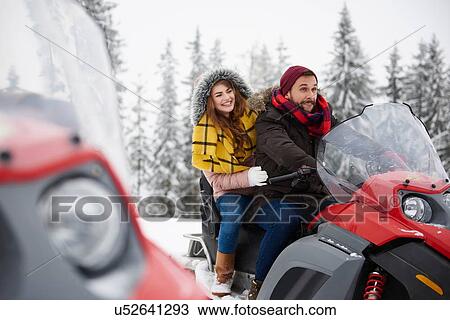 Young couple riding snowmobile in winter View Large Photo Image Stock Image - Young couple riding snowmobile in winter. Fotosearch