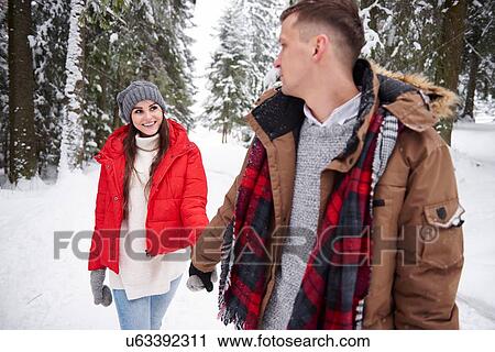 Young couple walking in snow View Large Photo Image Stock Image - Young couple walking in snow. Fotosearch