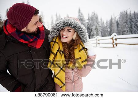 Stock Image - Young couple walking in snow. Fotosearch