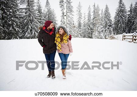 Stock Photo - Young couple walking in snow. Fotosearch