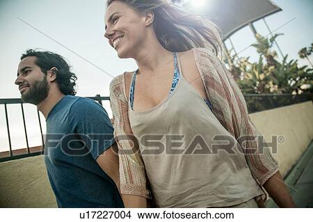 Young couple, walking outdoors, smiling View Large Photo Image Picture - Young couple, walking outdoors, smiling. Fotosearch
