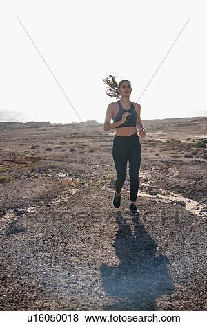 Young female runner running in arid coastal landscape, Las Palmas, Canary Islands, Spain View Large Photo Image Stock Photo - Young female runner running in arid coastal landscape, Las Palmas, Canary Islands, Spain. Fotosearch