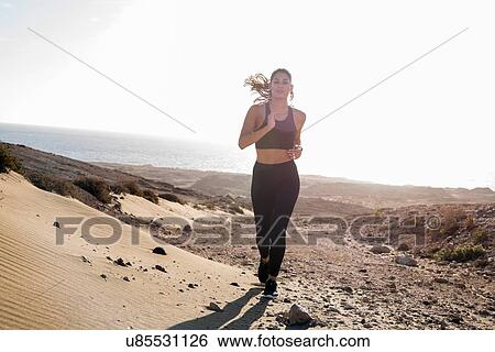 Young female runner running in arid coastal landscape, Las Palmas, Canary Islands, Spain View Large Photo Image Stock Photograph - Young female runner running in arid coastal landscape, Las Palmas, Canary Islands, Spain. Fotosearch
