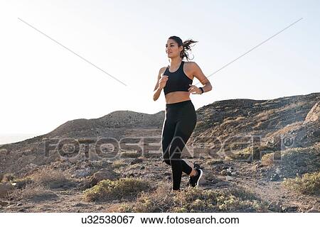 Young female runner running on dirt track in arid landscape, Las Palmas, Canary Islands, Spain View Large Photo Image Stock Photo - Young female runner running on dirt track in arid landscape, Las Palmas, Canary Islands, Spain. Fotosearch