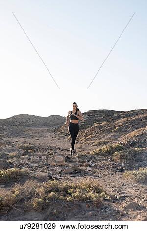Young female runner running on dirt track in arid landscape, Las Palmas, Canary Islands, Spain View Large Photo Image Stock Photo - Young female runner running on dirt track in arid landscape, Las Palmas, Canary Islands, Spain. Fotosearch