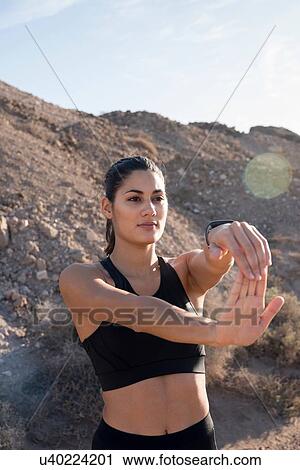 Young female runner stretching arms in arid landscape View Large Photo Image Stock Image - Young female runner stretching arms in arid landscape. Fotosearch
