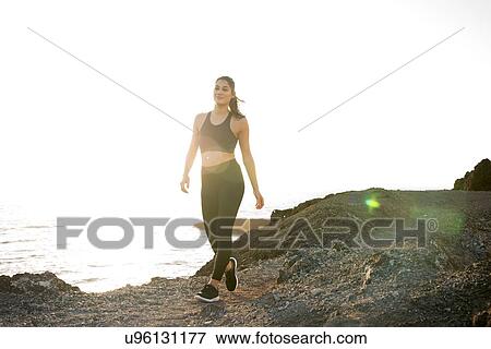 Stock Photo - Young female runner walking on coastal dirt track, Las Palmas, Canary Islands, Spain. Fotosearch