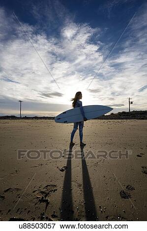 Young female surfer on beach, backlit, Tarragona, Catalonia, Spain View Large Photo Image Stock Photo - Young female surfer on beach, backlit, Tarragona, Catalonia, Spain. Fotosearch