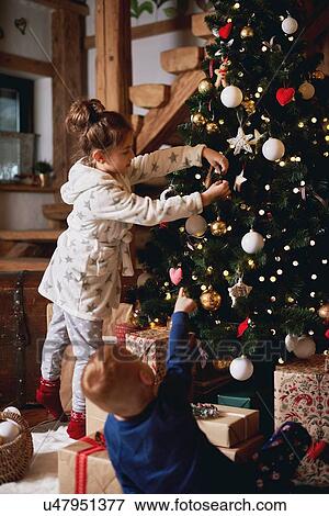 Young girl and boy decorating Christmas tree View Large Photo Image Stock Photo - Young girl and boy decorating Christmas tree. Fotosearch