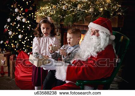 Young girl and boy visiting Santa, receiving gifts View Large Photo Image Stock Photo - Young girl and boy visiting Santa, receiving gifts. Fotosearch