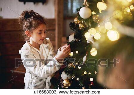 Young girl decorating Christmas tree View Large Photo Image Stock Image - Young girl decorating Christmas tree. Fotosearch