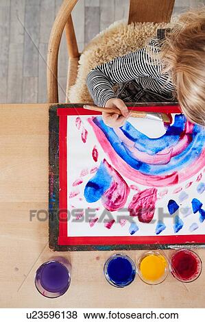Young girl sitting at table, painting picture, overhead view View Large Photo Image Stock Photo - Young girl sitting at table, painting picture, overhead view. Fotosearch
