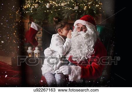 Young girl sitting with Santa, whispering into Santa's ear View Large Photo Image Stock Image - Young girl sitting with Santa, whispering into Santa's ear. Fotosearch