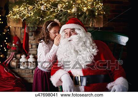 Young girl visiting Santa, whispering into Santa's ear View Large Photo Image Stock Image - Young girl visiting Santa, whispering into Santa's ear. Fotosearch