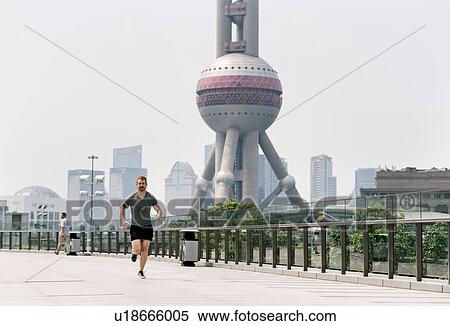 Young male runner running in Shanghai financial centre, Shanghai, China View Large Photo Image Stock Photography - Young male runner running in Shanghai financial centre, Shanghai, China. Fotosearch