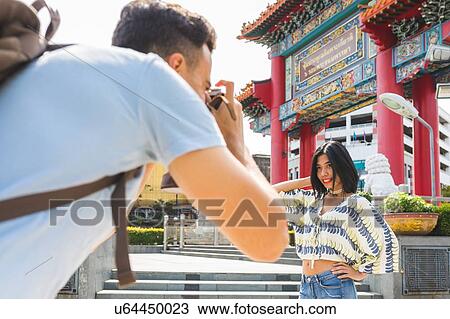 Young male tourist photographing girlfriend by temple, Bangkok, Thailand View Large Photo Image Stock Image - Young male tourist photographing girlfriend by temple, Bangkok, Thailand. Fotosearch