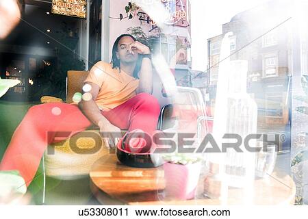 Stock Image - Young man relaxing in bar. Fotosearch