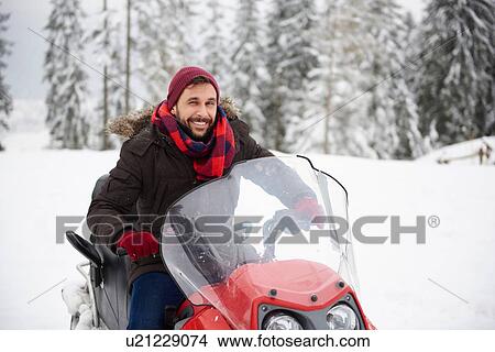 Young man riding snowmobile in winter View Large Photo Image Picture - Young man riding snowmobile in winter. Fotosearch