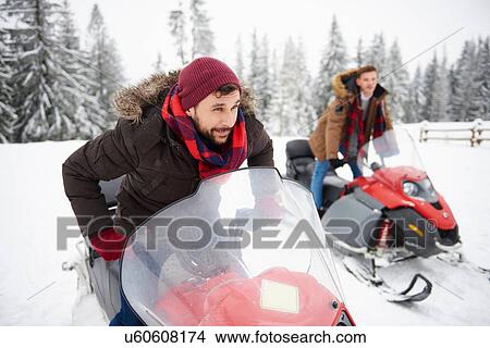 Young men riding snowmobiles in winter View Large Photo Image Picture - Young men riding snowmobiles in winter. Fotosearch