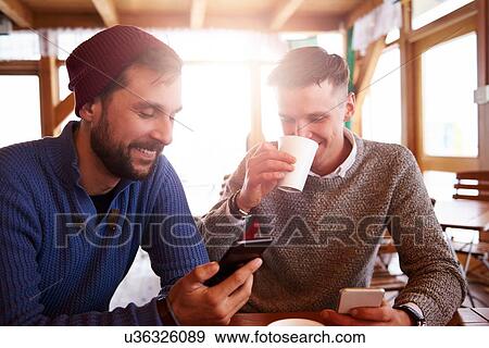 Young men smiling over text message on mobile phones View Large Photo Image Stock Photo - Young men smiling over text message on mobile phones. Fotosearch