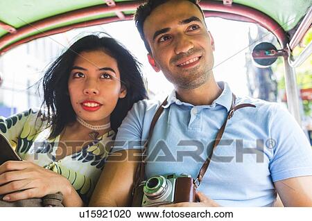 Stock Image - Young tourist couple in auto rickshaw with camera, Bangkok, Thailand. Fotosearch