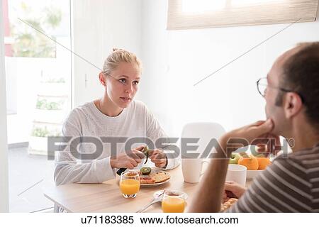 Young woman and boyfriend peeling kiwi fruit at breakfast table View Large Photo Image Stock Photography - Young woman and boyfriend peeling kiwi fruit at breakfast table. Fotosearch