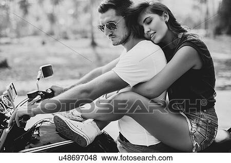 Stock Photo - Young woman astride boyfriend on motorcycle, Krabi, Thailand, B&W. Fotosearch