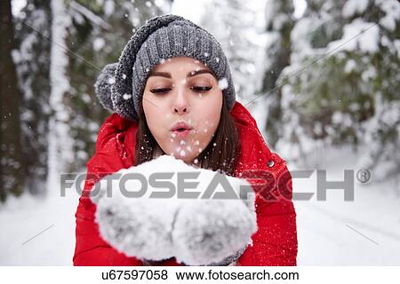 Young woman blowing snowflakes off hands View Large Photo Image Stock Photo - Young woman blowing snowflakes off hands. Fotosearch