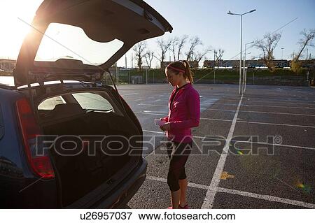 Young woman by open car boot View Large Photo Image Stock Photo - Young woman by open car boot. Fotosearch