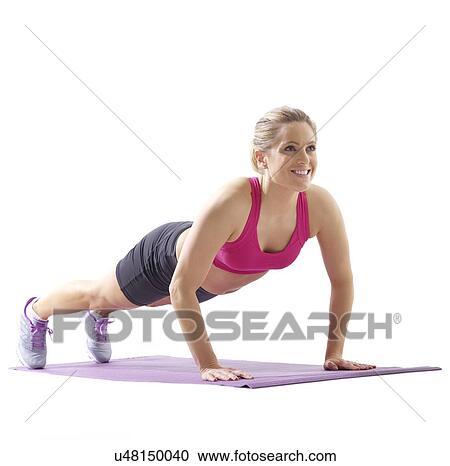 Stock Image - Young woman doing high plank, studio shot.. Fotosearch