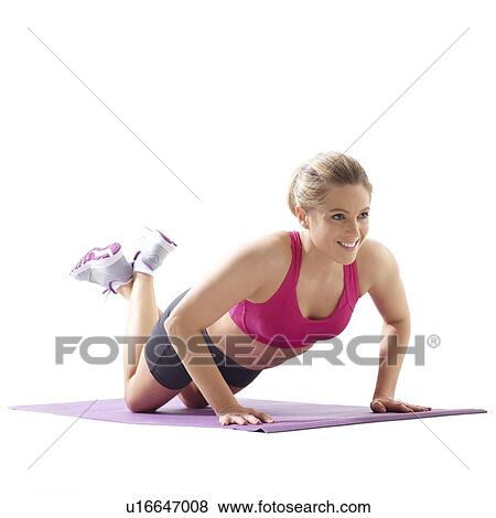 Young woman doing push up with legs crossed at ankle, studio shot. View Large Photo Image Stock Photo - Young woman doing push up with legs crossed at ankle, studio shot.. Fotosearch