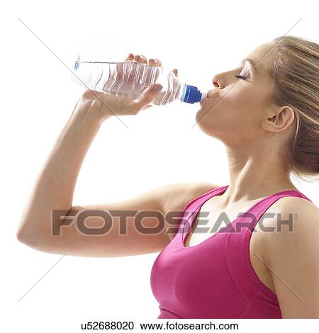 Young woman drinking from water bottle, studio shot. View Large Photo Image Stock Image - Young woman drinking from water bottle, studio shot.. Fotosearch