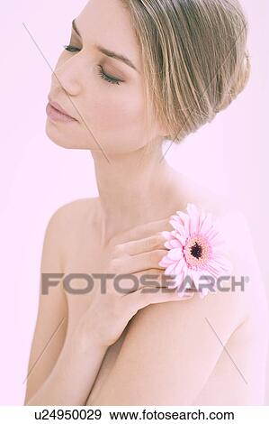 Stock Photo - Young woman holding flower, portrait.. Fotosearch